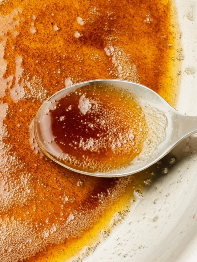 A closeup of a spoon filled with browned butter.