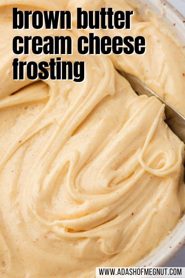 Brown butter cream cheese frosting swirled with a spatula in a bowl.