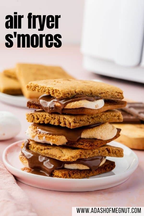A stack of three air fryer s'mores on a plate with gluten-free graham crackers and an air fryer in the background.