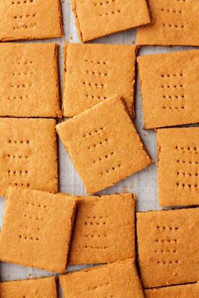 Graham cracker squares spread out on a piece of parchment paper.