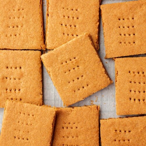 Graham cracker squares spread out on a piece of parchment paper.