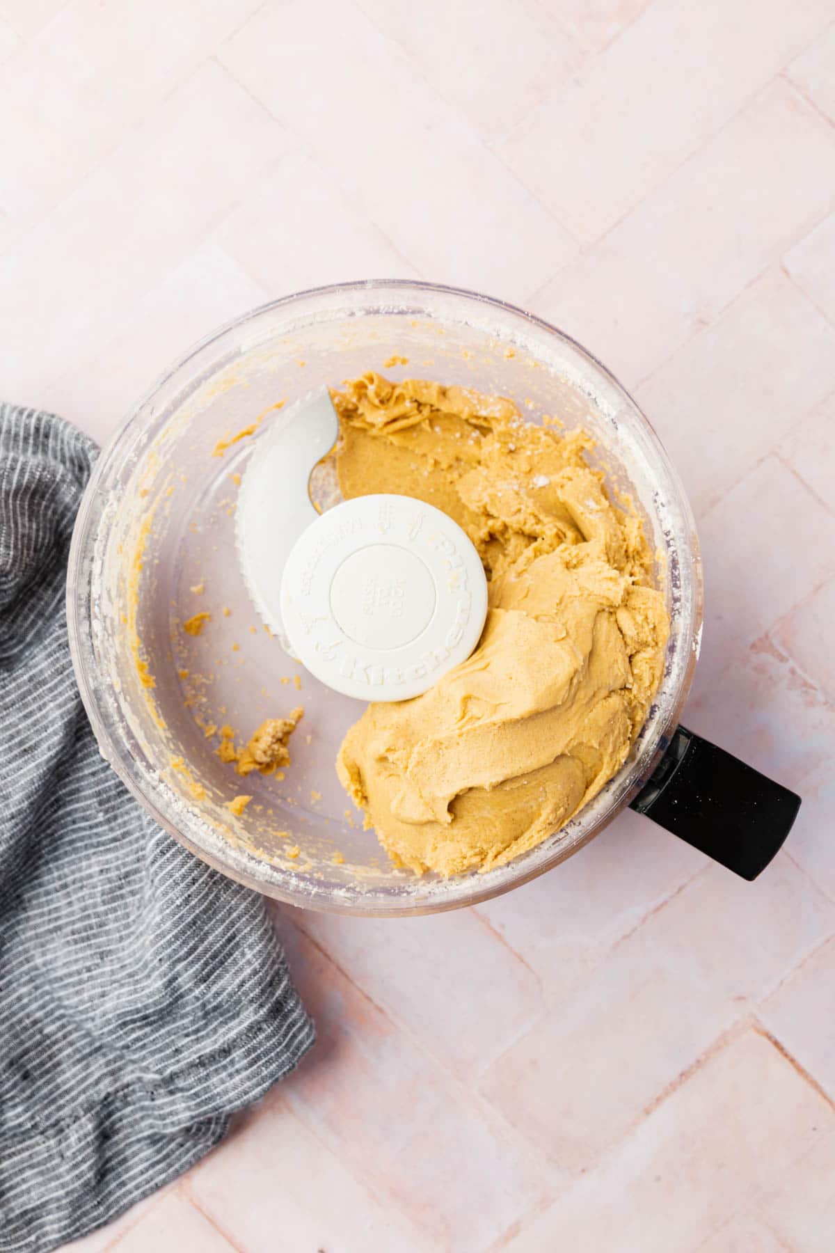 A food processor with gluten-free graham cracker dough in it. 
