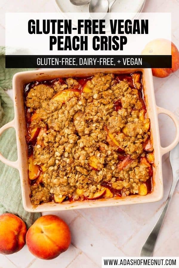 An overhead view of baked peach crisp in a square baking dish with fresh peaches surrounding the dish.