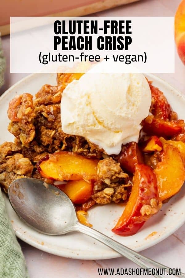 A single serving of gluten-free vegan peach crisp on a round plate topped with a scoop of vanilla ice cream with a spoon on the plate.
