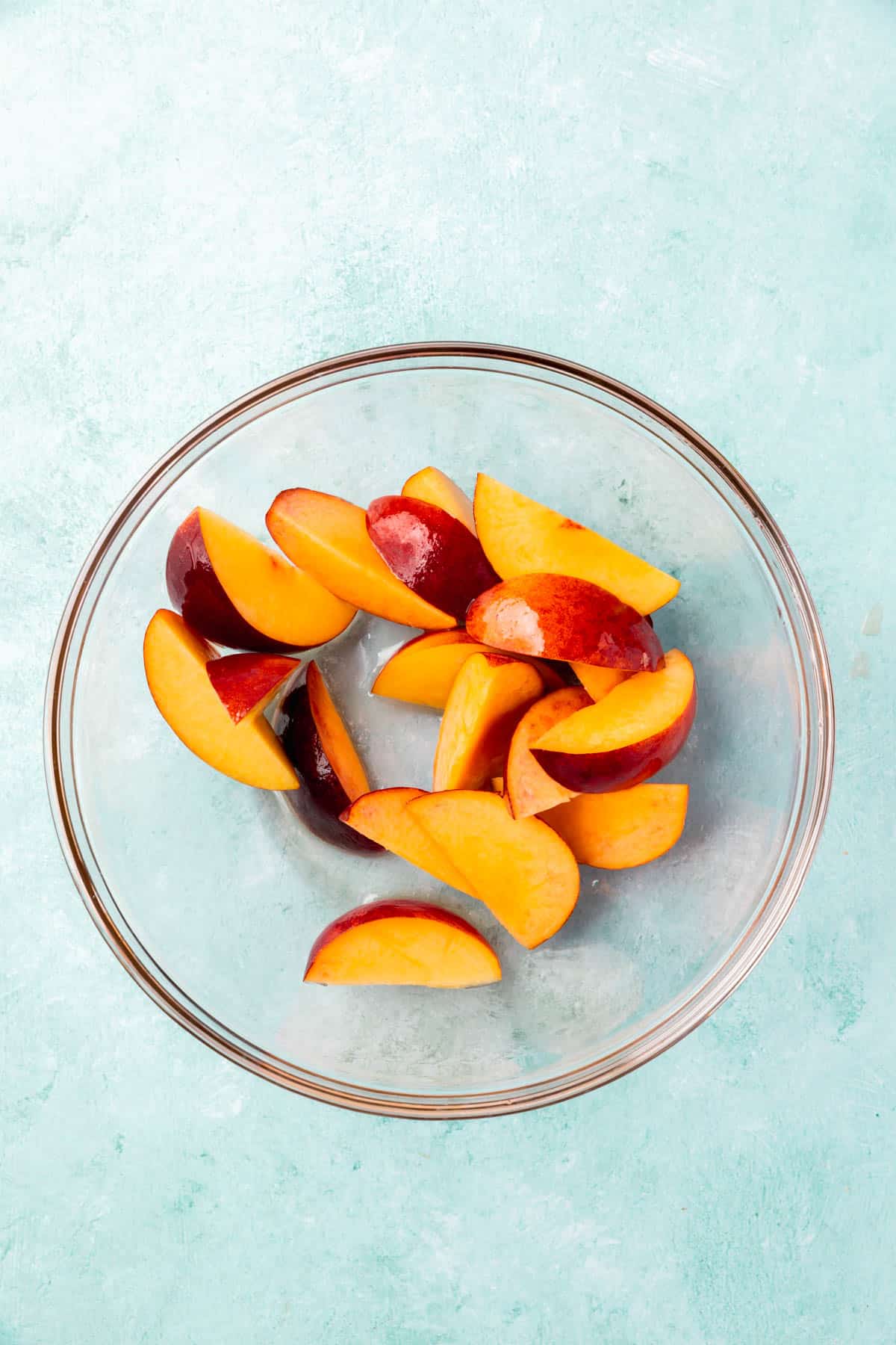 A bowl of peach slices tossed in avocado oil.