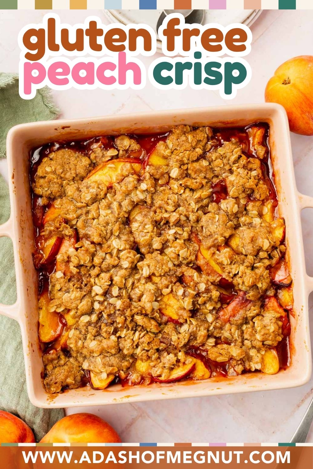 A square baking dish filled with gluten-free peach crisp, topped with a golden oat crumble and surrounded by fresh peaches. The text reads “gluten-free peach crisp” and “www.adashofmegnut.com.”.