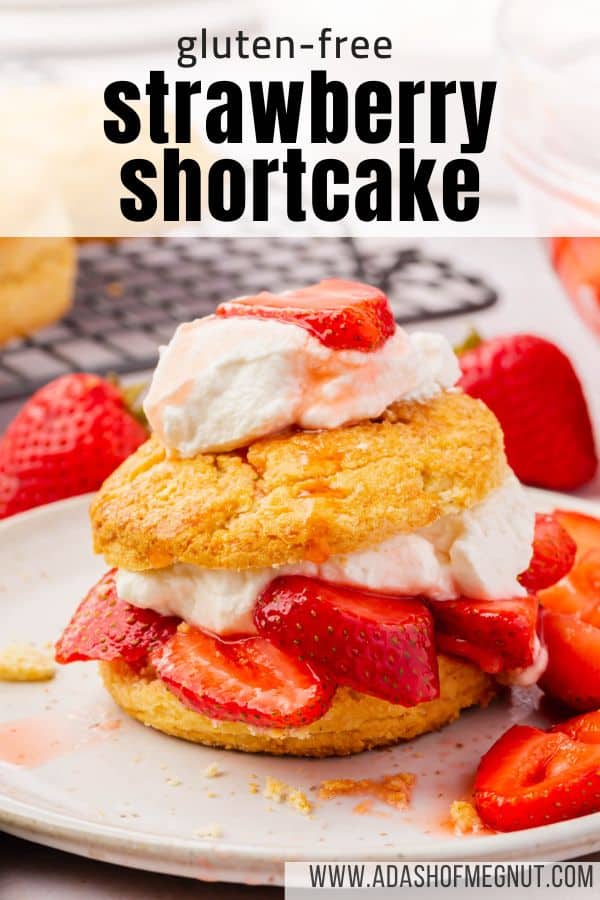 An individual gluten-free strawberry shortcake on a dessert plate with slices of fresh strawberries around.