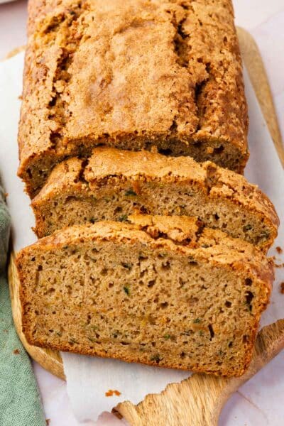 Two slices of gluten-free zucchini bread leaning against the rest of the loaf.