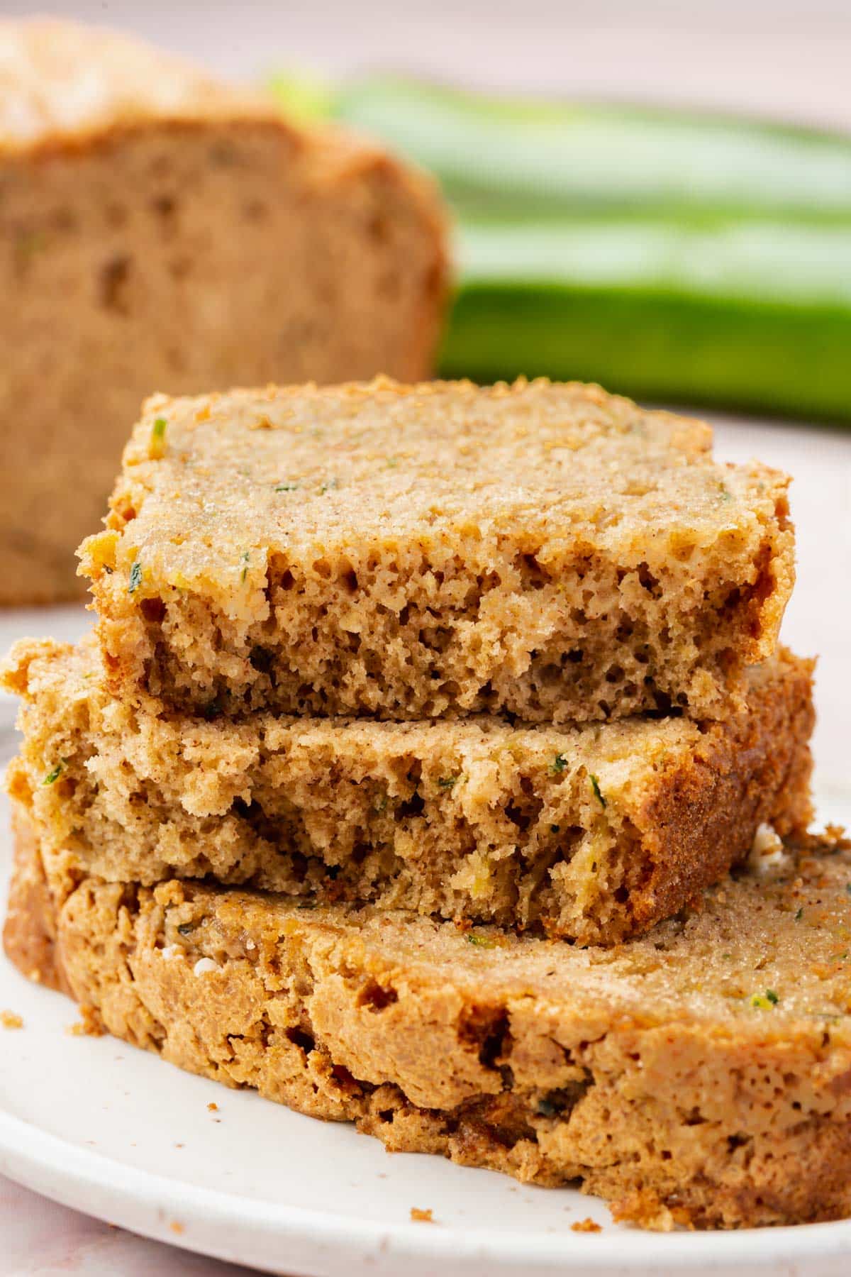Three pieces of gluten-free zucchini bread stacked on top of each other.
