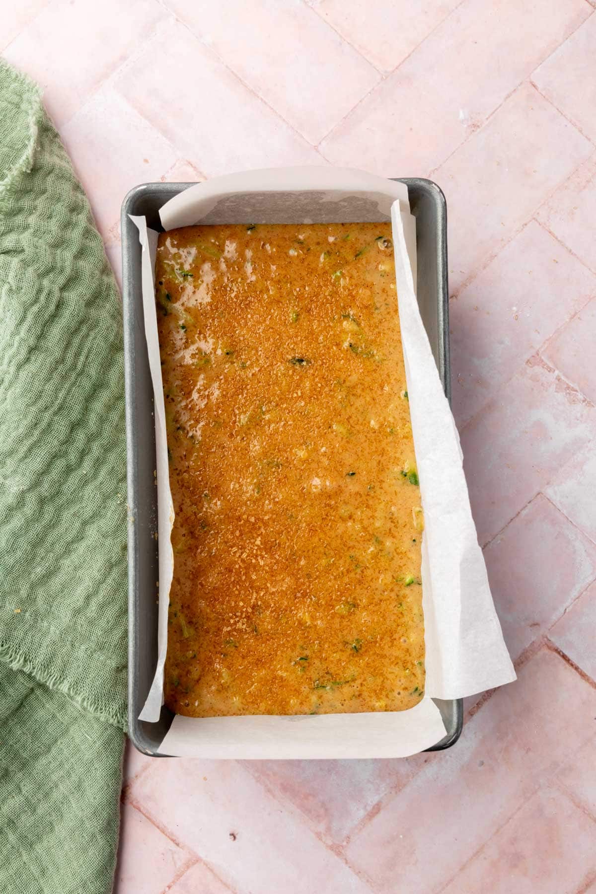 Gluten-free zucchini bread batter in a lined loaf pan before baking.