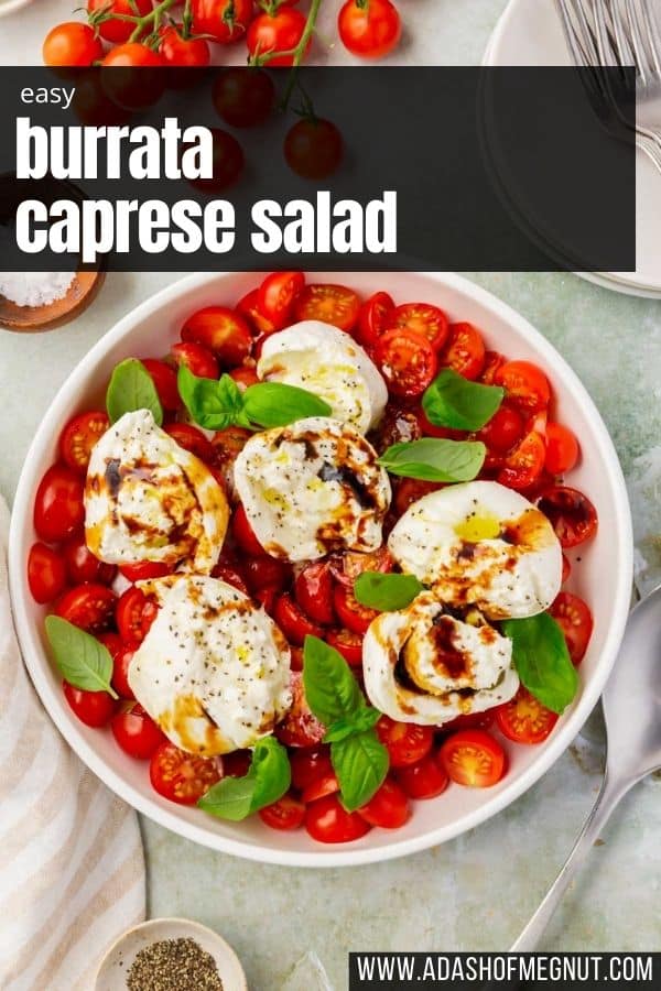 An overhead view of a bowl of burrata caprese salad topped with basil and balsamic glaze.