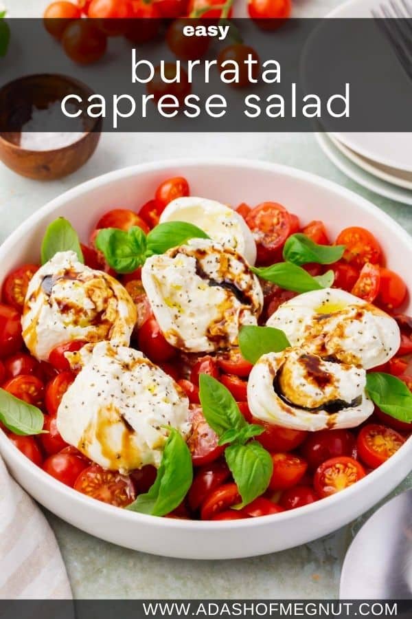 A bowl of burrata caprese salad topped with basil.