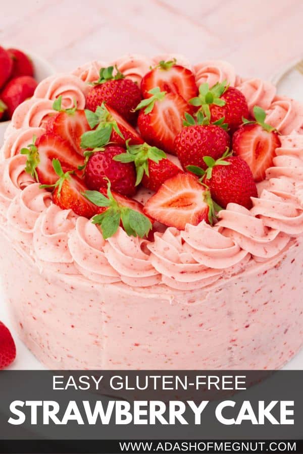 A whole uncut gluten-free strawberry cake frosted with strawberry buttercream piping and halved strawberries with text overlay.