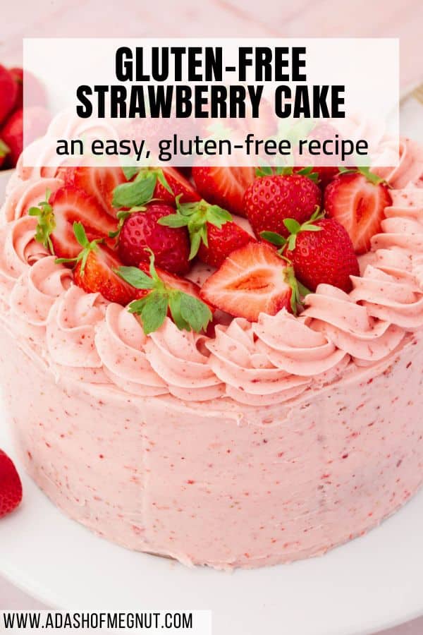 A whole uncut gluten-free strawberry cake frosted with strawberry buttercream piping and halved strawberries with text overlay.