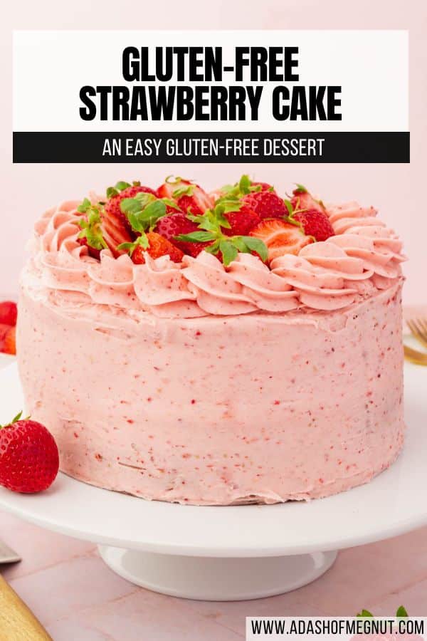 A whole uncut gluten-free strawberry cake frosted with strawberry buttercream piping and halved strawberries with text overlay.