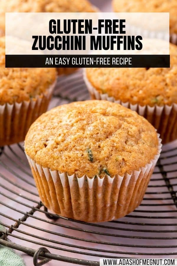 A closeup of a gluten-free zucchini muffin on a round cooling rack with more muffins in the background.