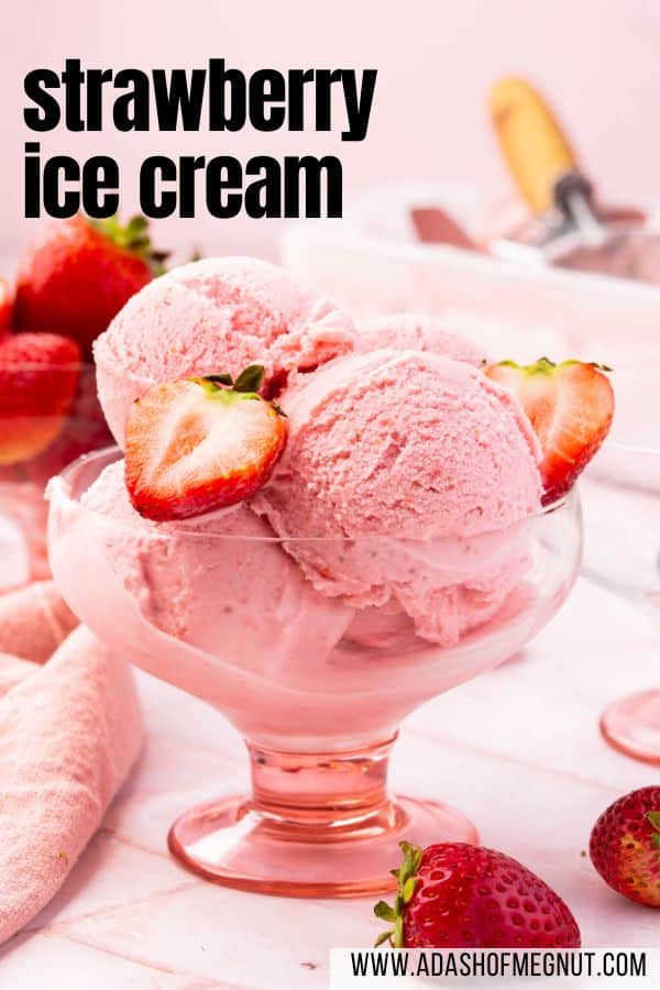 A pink bowl of strawberry ice cream topped with strawberry halves.