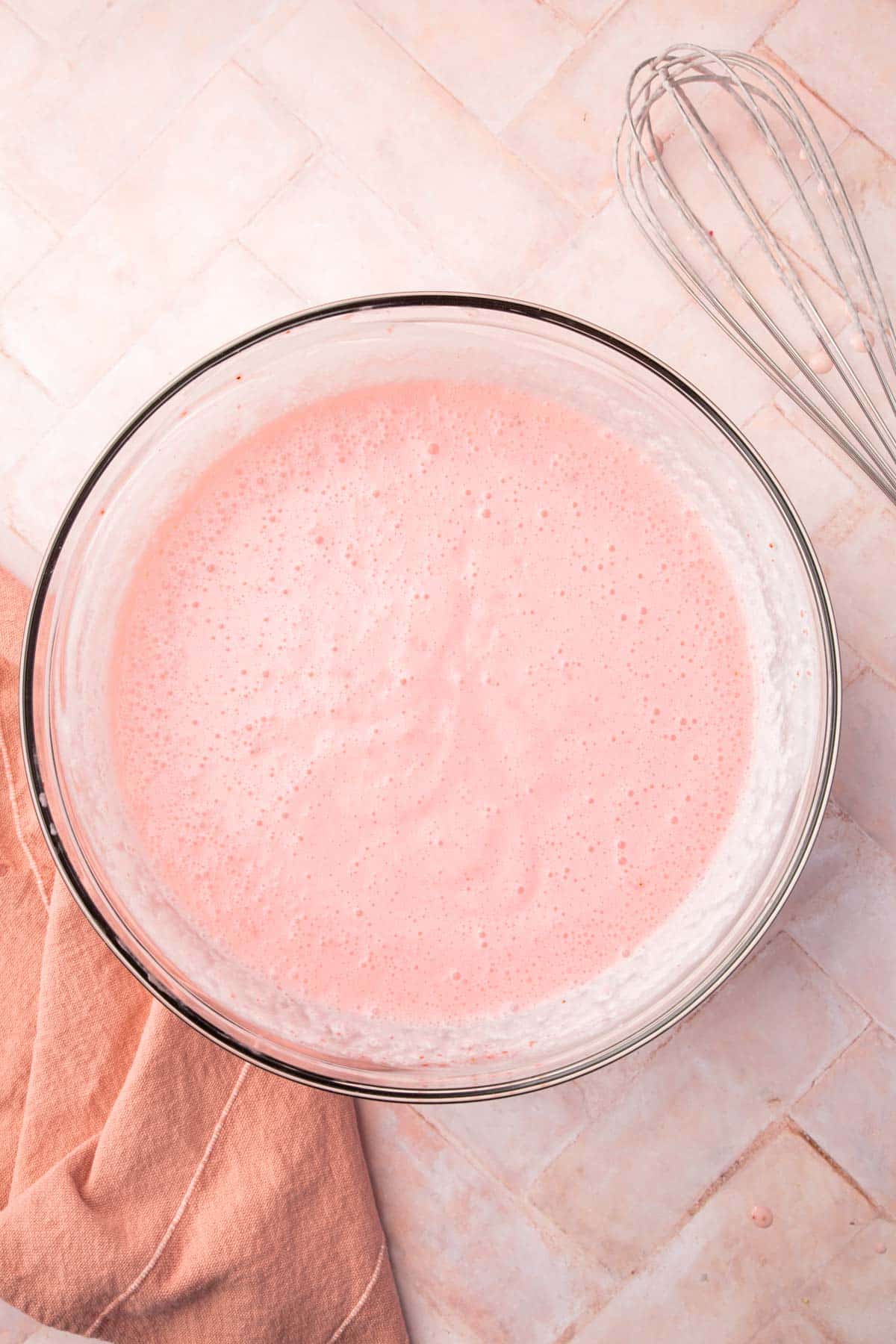 A glass bowl of strawberry ice cream base before churning.