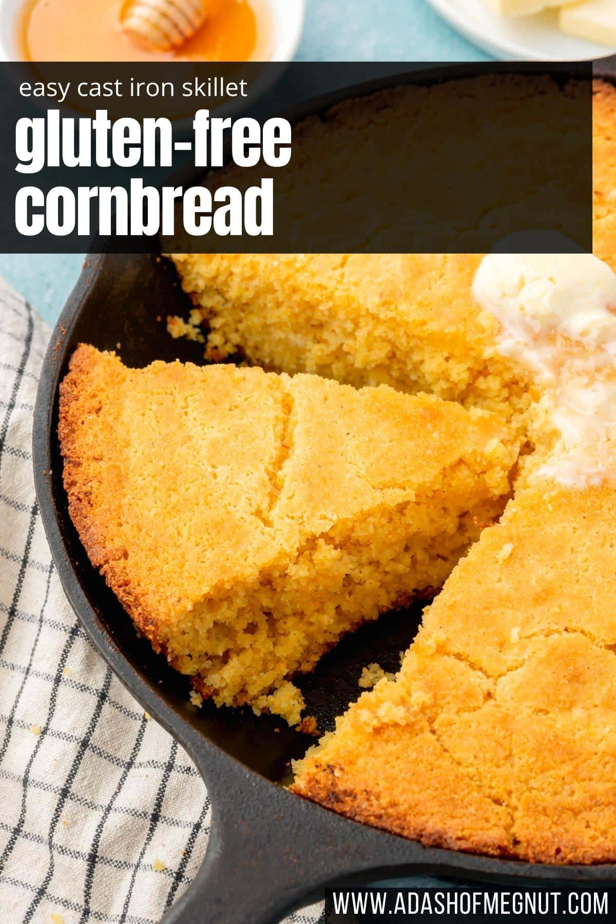 A slice of gluten-free cornbread in a cast iron skillet that has been cut away from the remaining whole cornbread.
