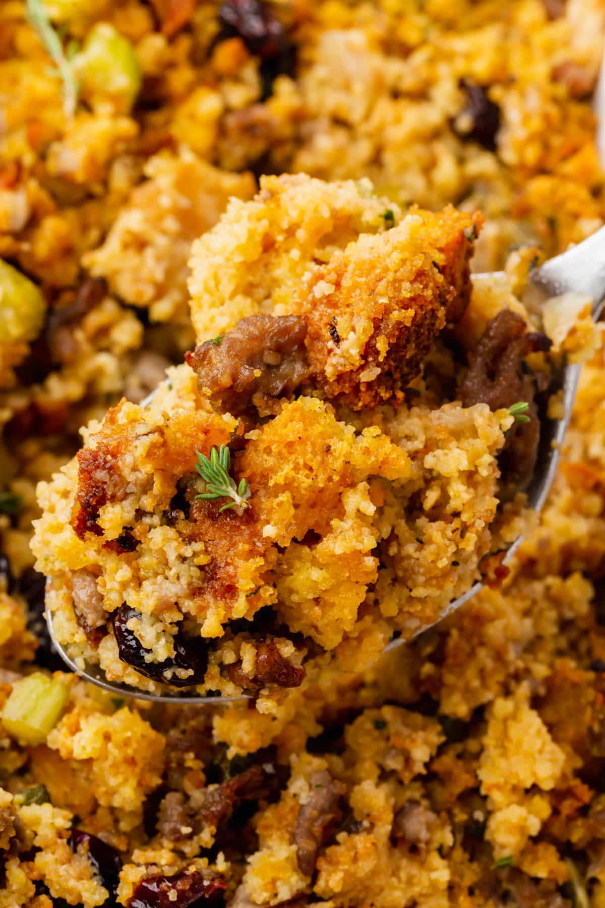A spoonful of gluten-free cornbread stuffing over the larger casserole dish of stuffing.