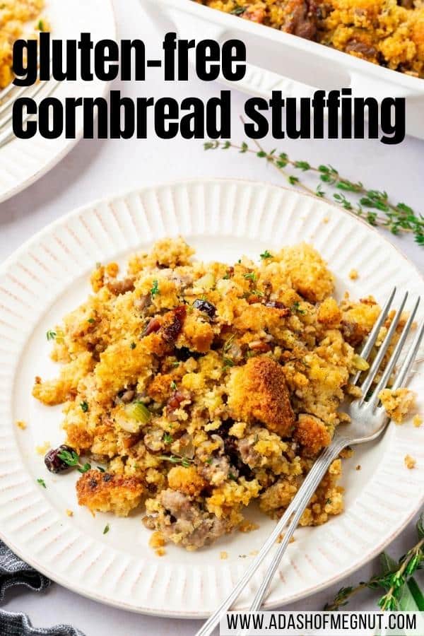 A plate with gluten-free cornbread stuffing and a fork with fresh thyme on the table.