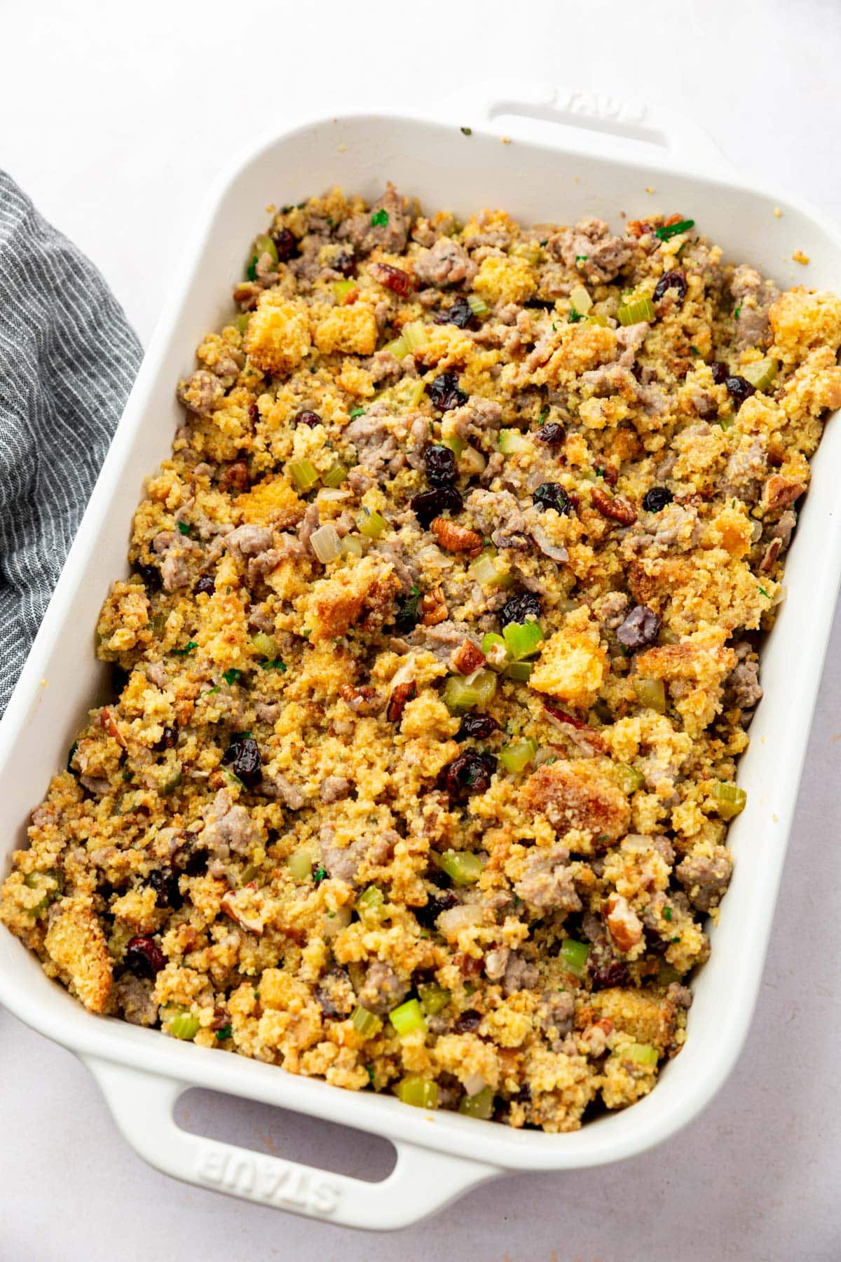 A rectangular baking dish of gluten-free cornbread stuffing before baking in the oven.