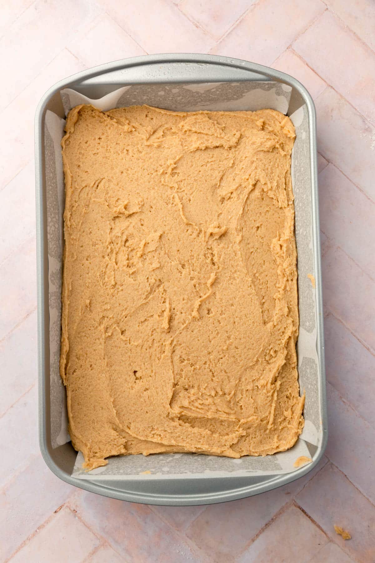 Gluten-free snickerdoodle cookie dough in a rectangle baking pan.