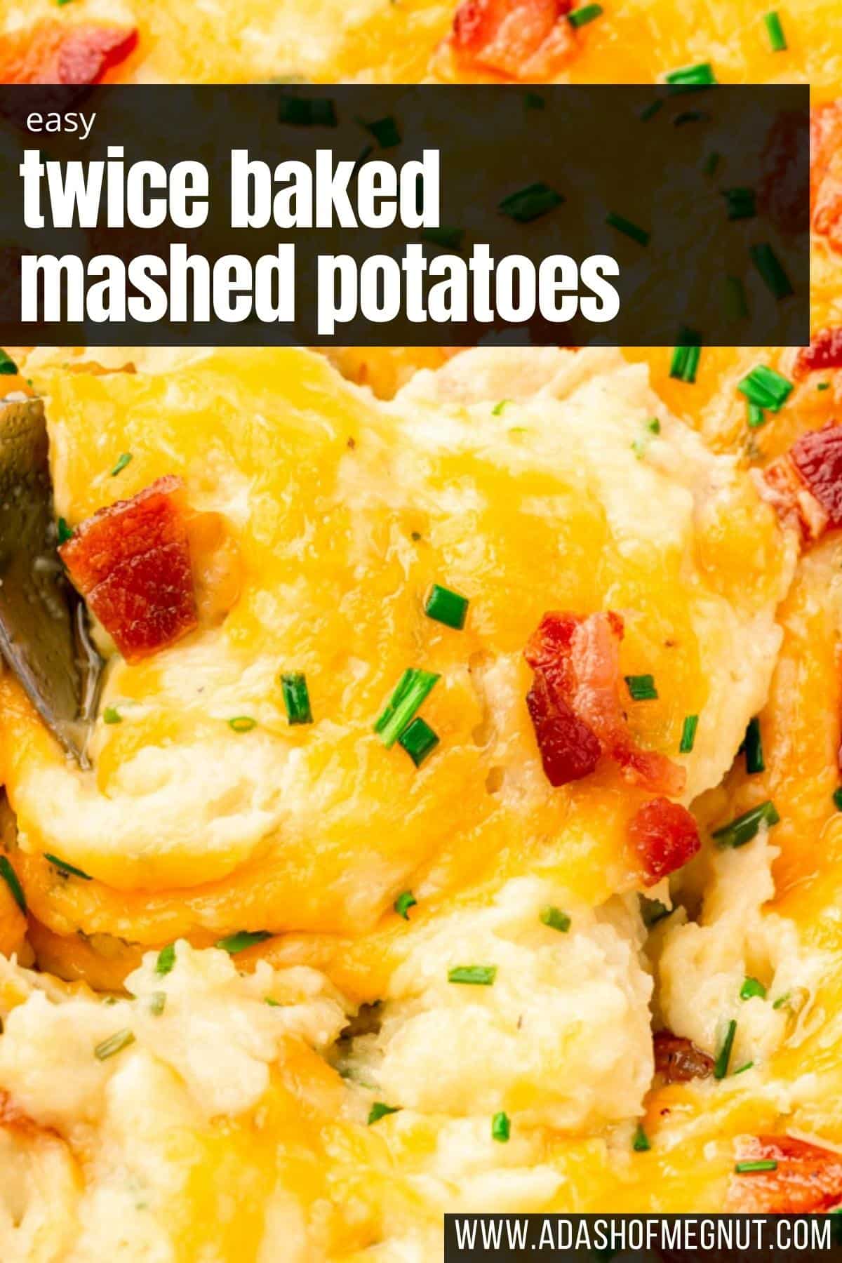 A spoon digging into a casserole dish of mashed potatoes topped with bacon and cheddar cheese.