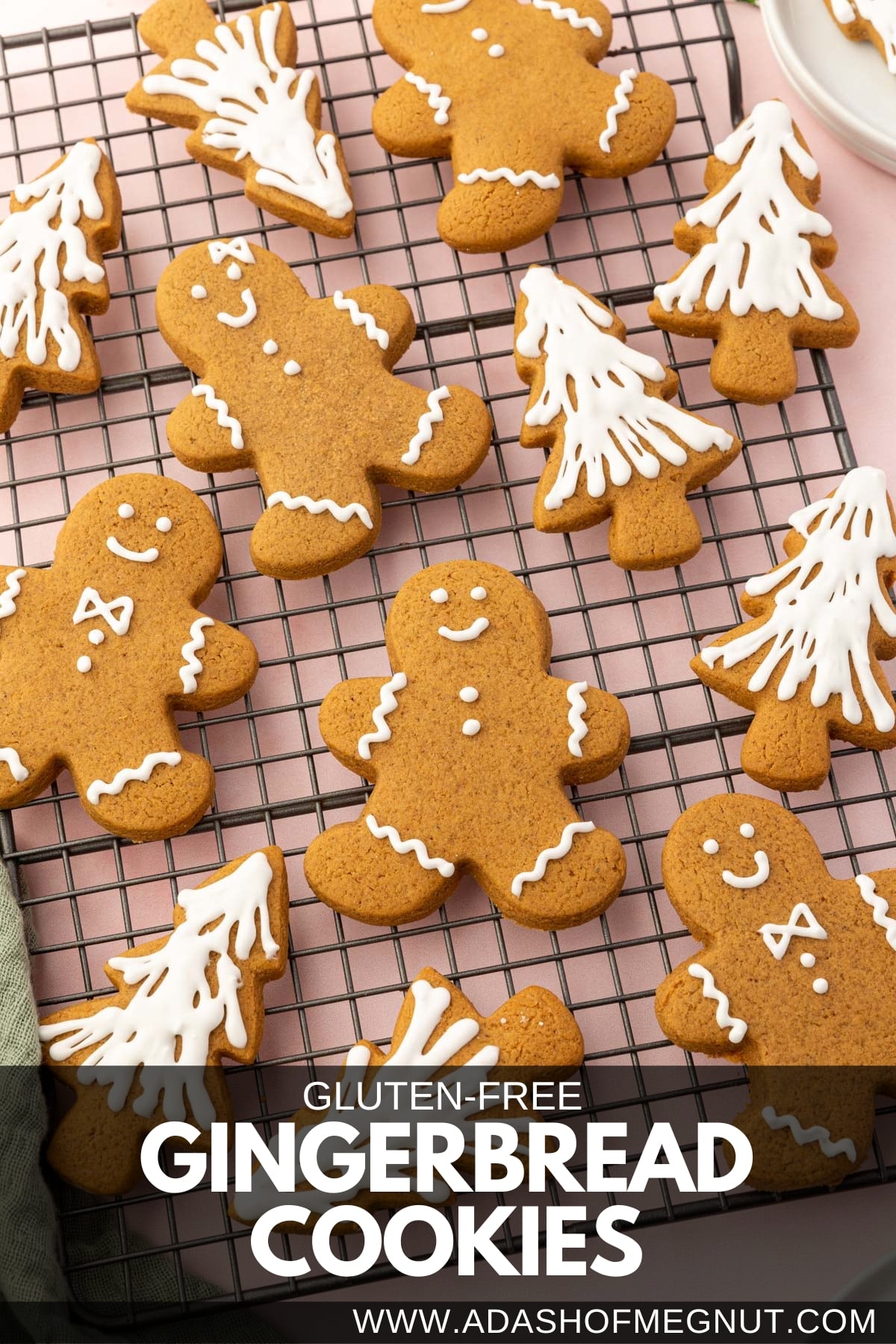 A cooling rack with gluten-free gingerbread men and gingerbread christmas tree cookies on it frosted with white royal icing.