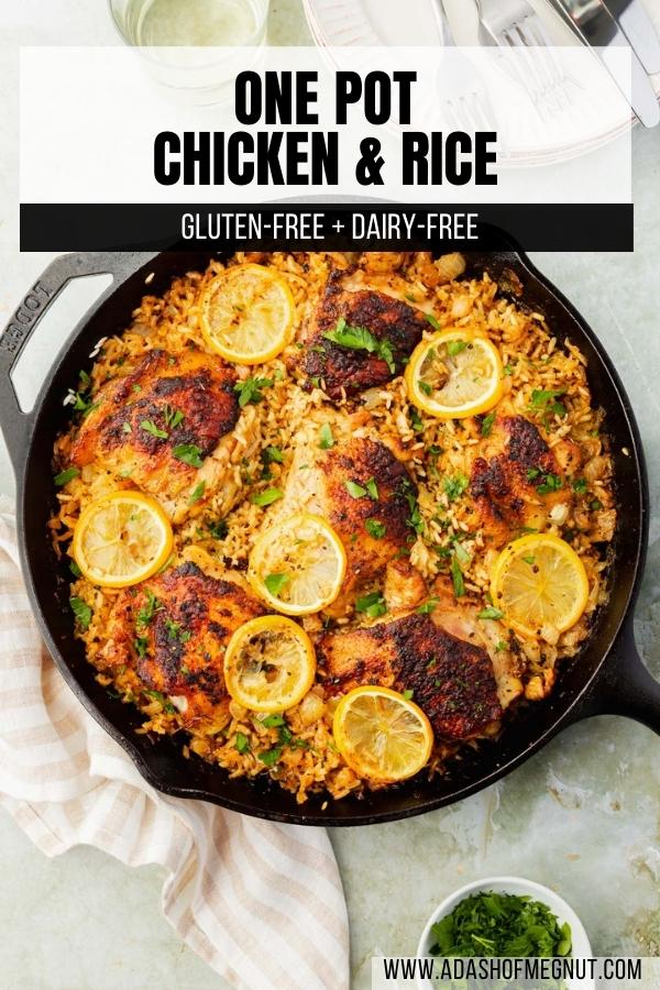 A close up of roasted chicken thighs on top of a bed of seasoned white rice and topped with charred lemon slices and fresh parsley in a cast iron skillet.