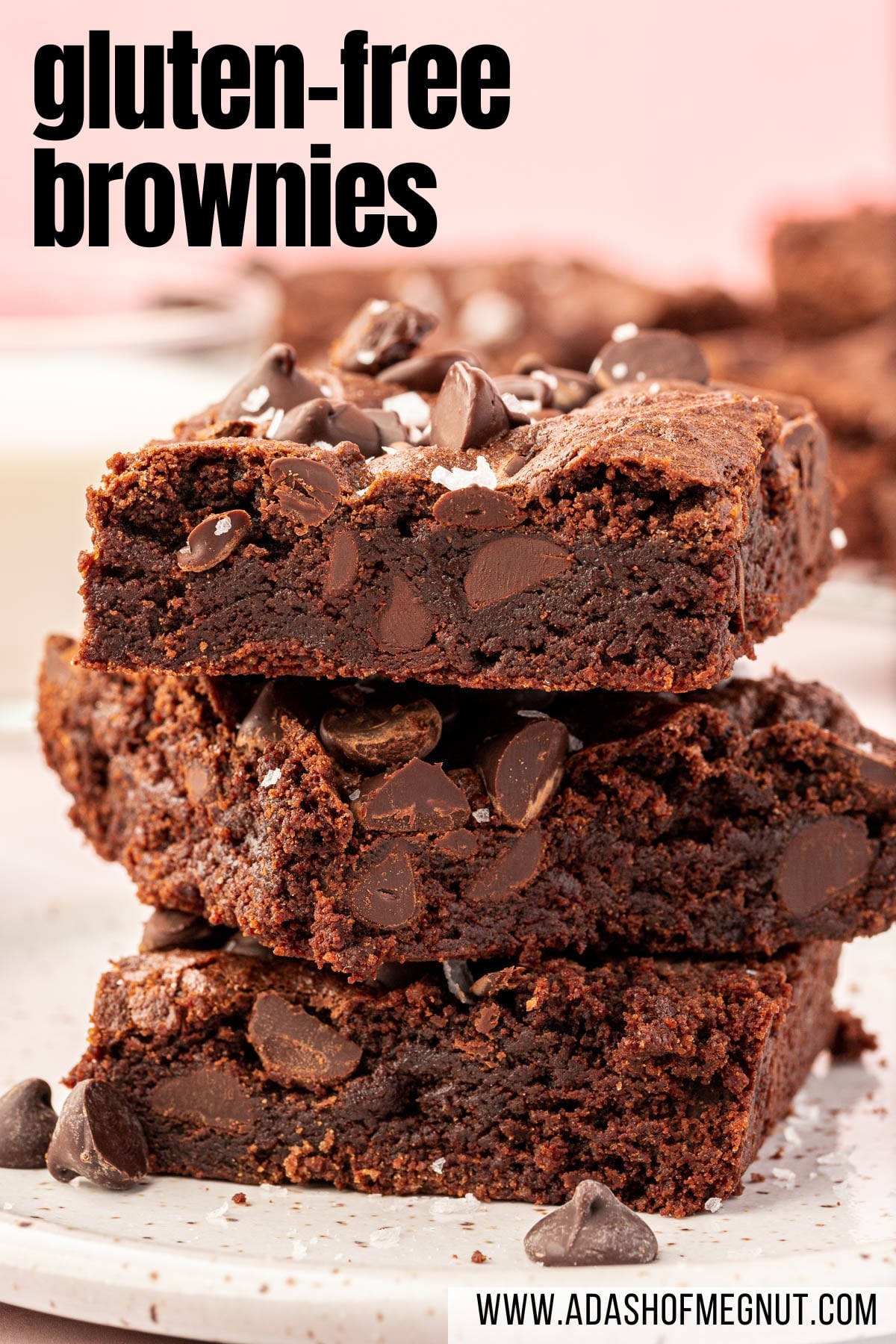 A stack of three gluten-free brownies on a small dessert plate topped with semi-sweet chocolate chips and flaky sea salt with a text overlay.