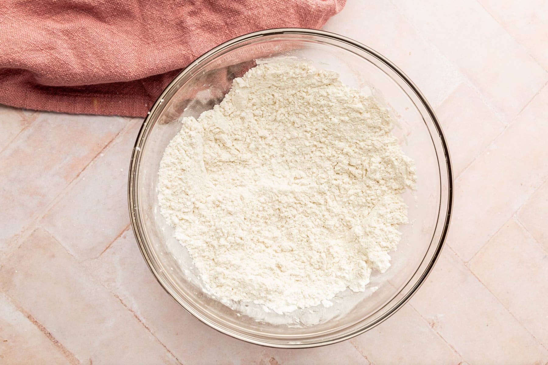 A glass mixing bowl with a gluten-free flour blend mixture in it.