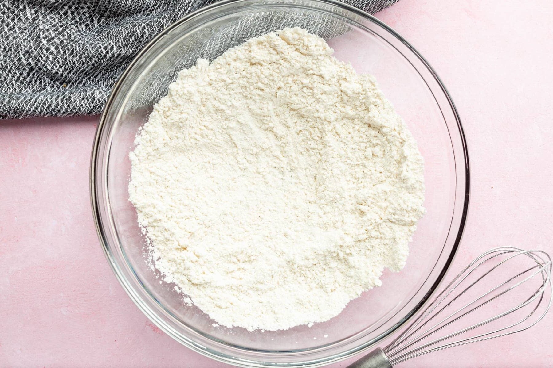 A glass mixing bowl with gluten-free flour in it.
