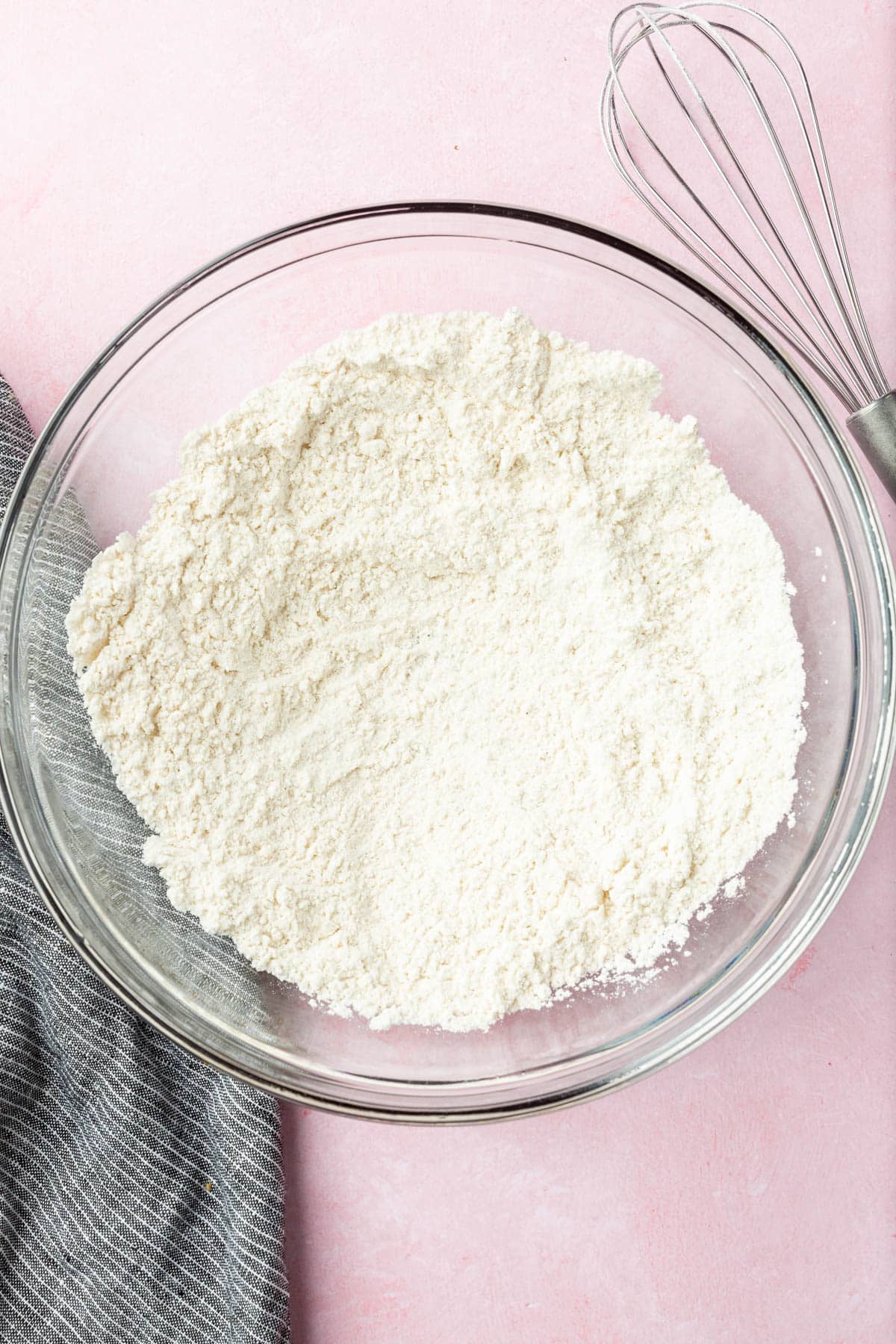 A glass mixing bowl with gluten-free flour in it.