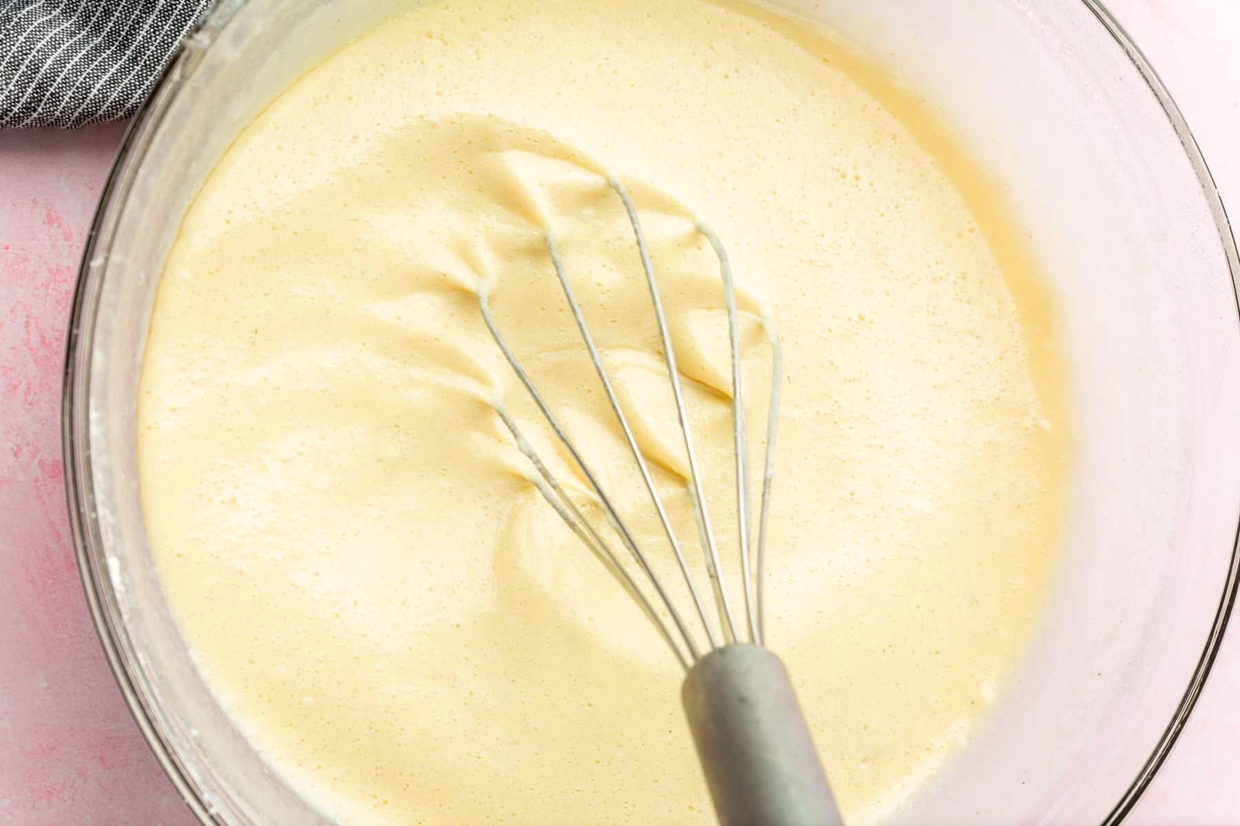 Gluten-free crepe batter being whisked in a large mixing bowl.