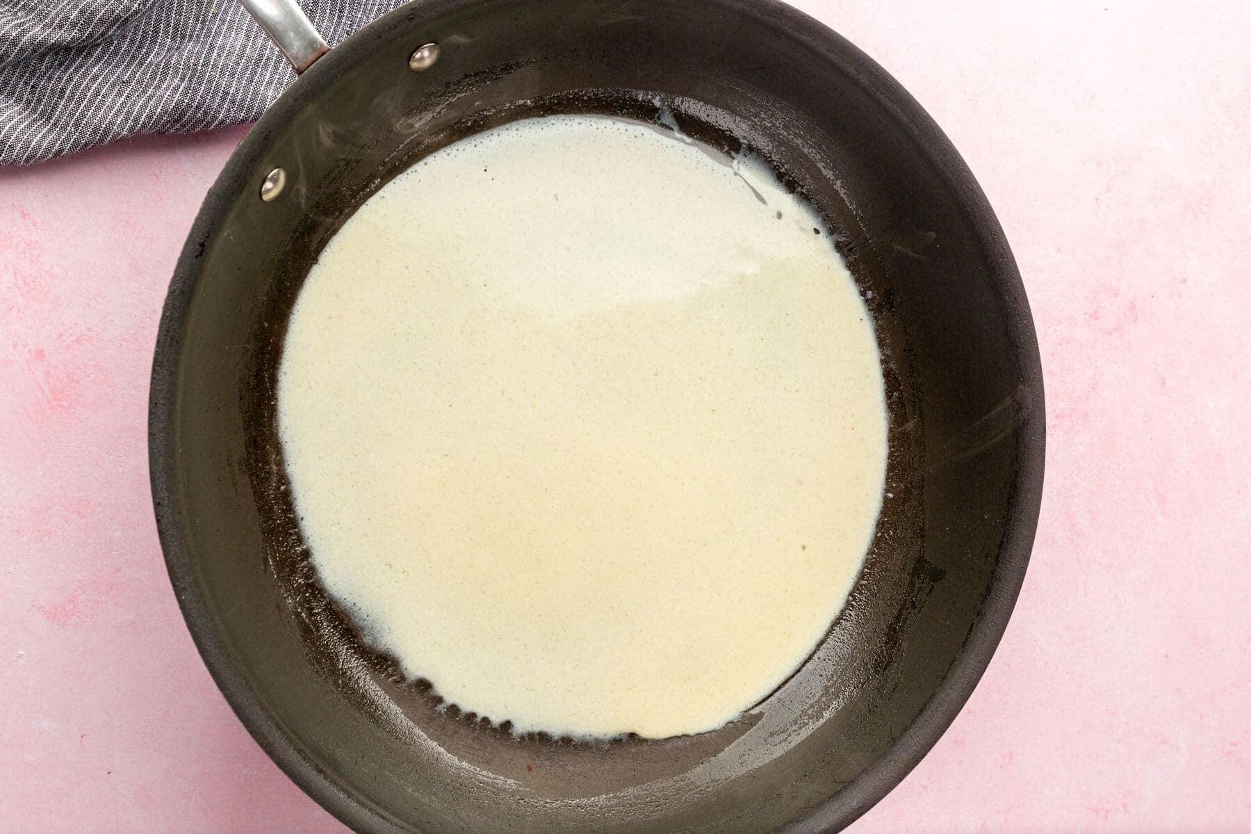 Gluten-free crepe batter in a non-stick skillet.