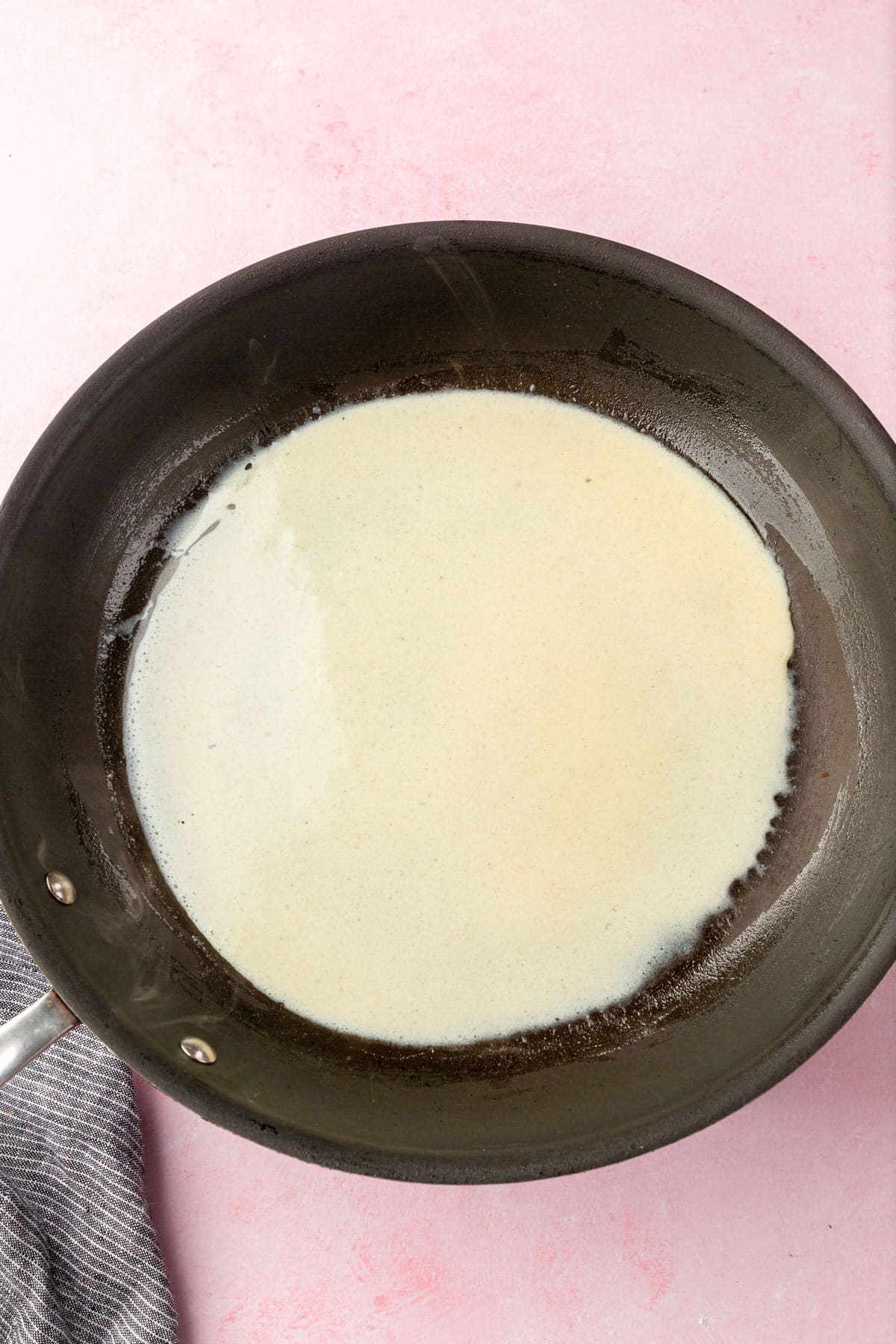 Gluten-free crepe batter in a non-stick skillet.