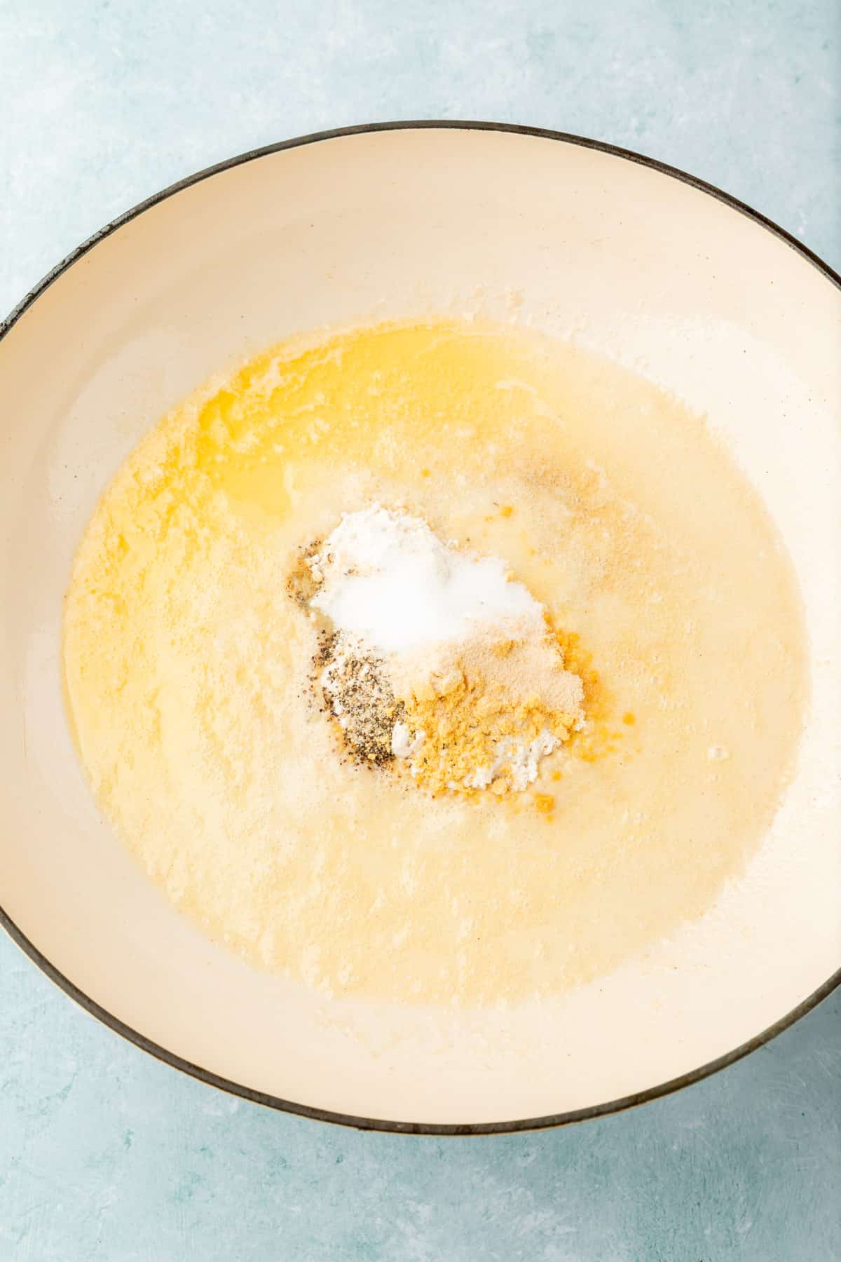 Melted butter, salt, pepper, gluten-free flour, onion powder and dry mustard powder in a skillet before mixing together.