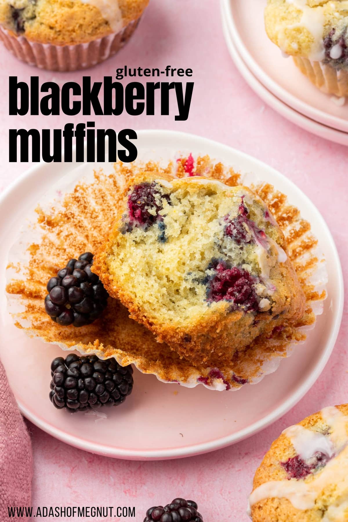 A single blackberry muffin with a bite taken out of it on a dessert plate with more muffins surrounding.