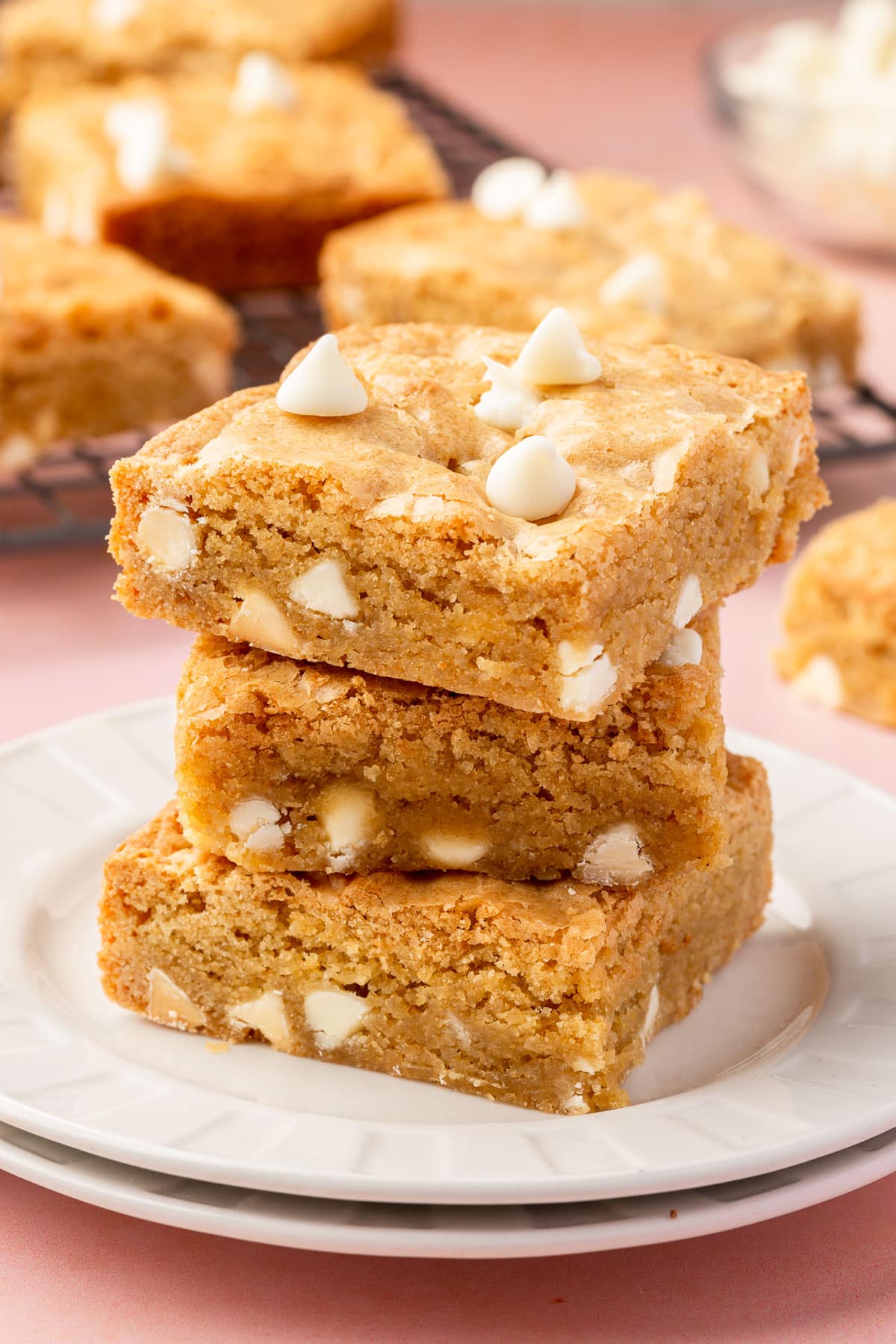A stack of three gluten-free blondies topped with white chocolate chips.