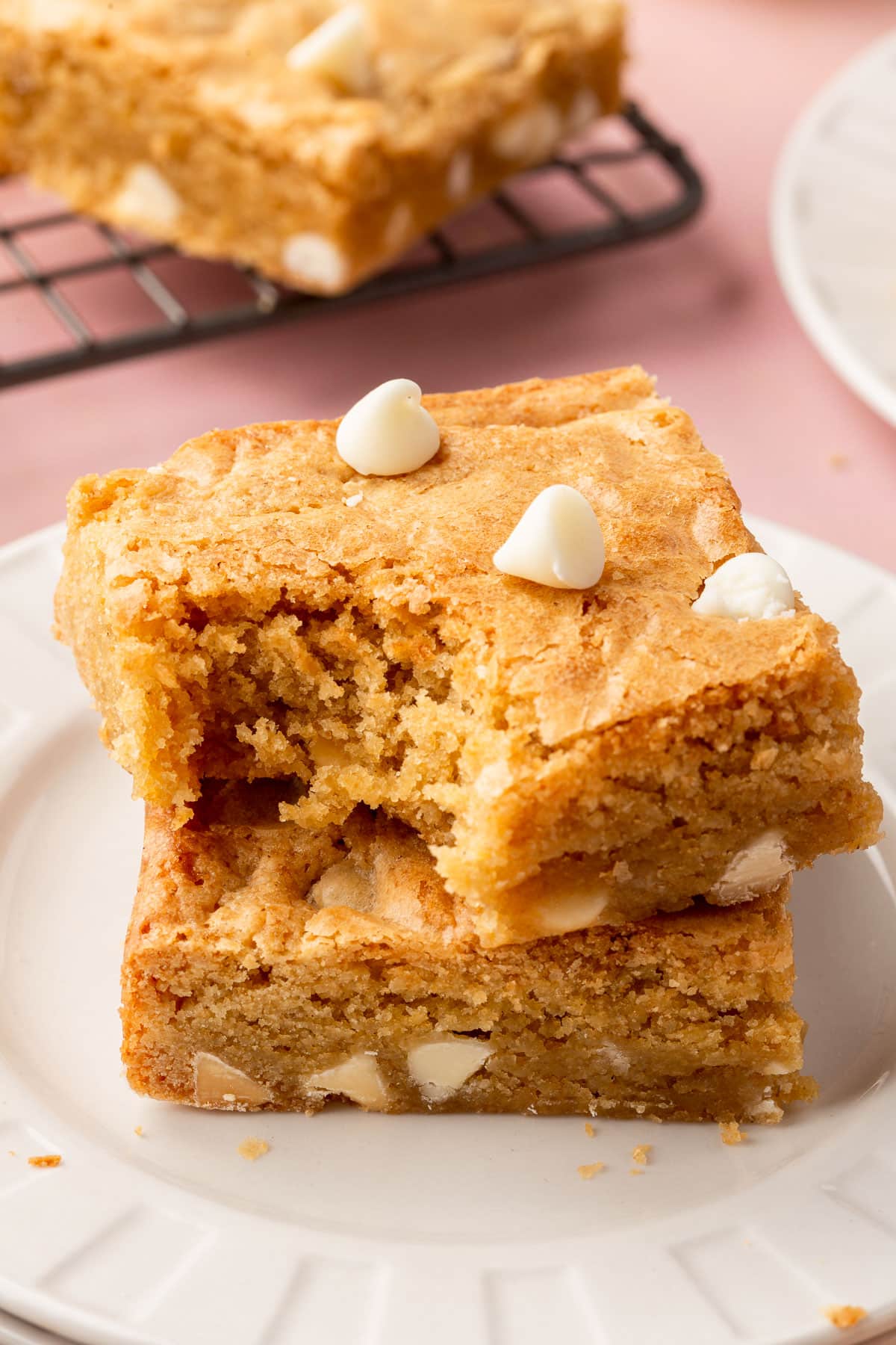 A stack of two gluten-free blondies with a bite taken out of the top blondie.