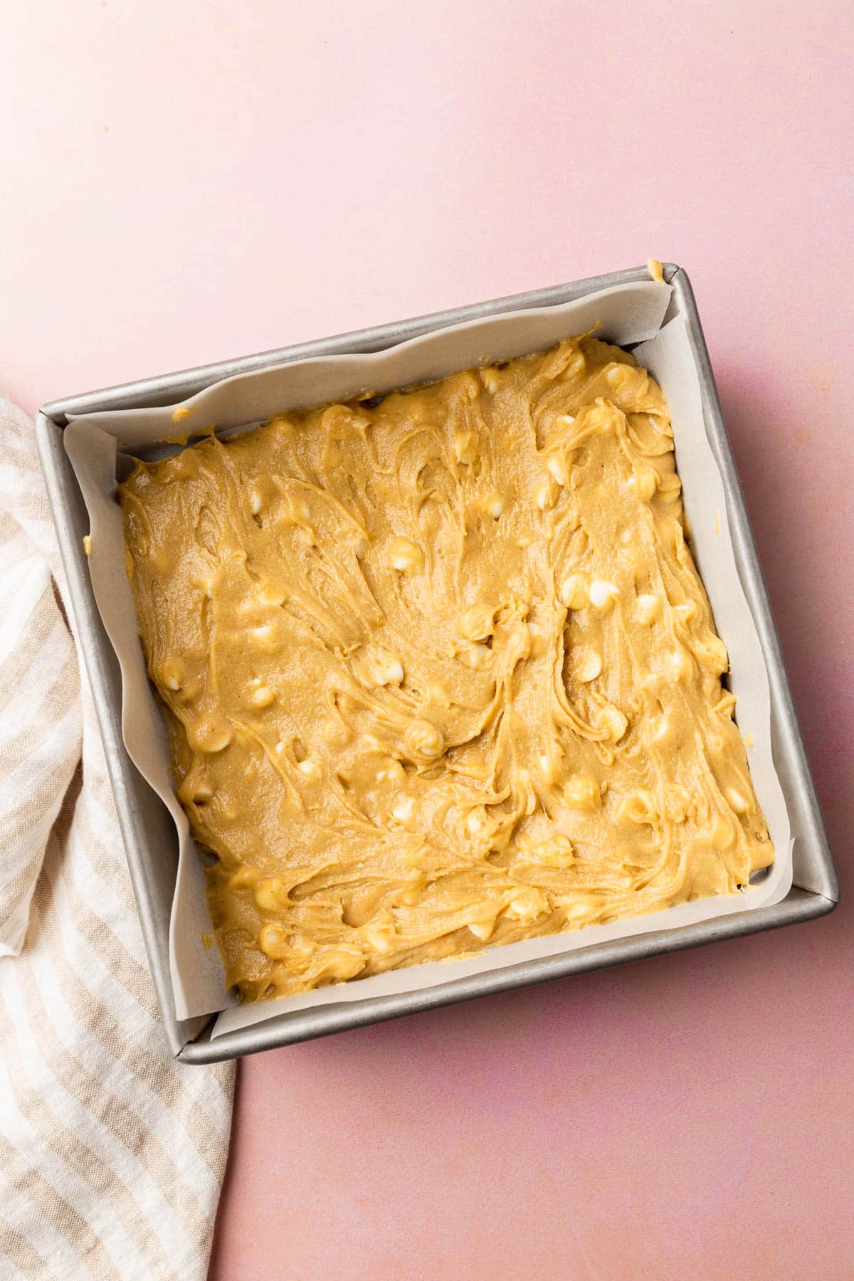 A square baking dish with gluten-free blondie batter in it before baking in the oven.