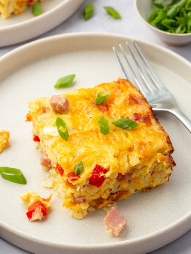 A slice of gluten free hash brown casserole on a plate with a fork.