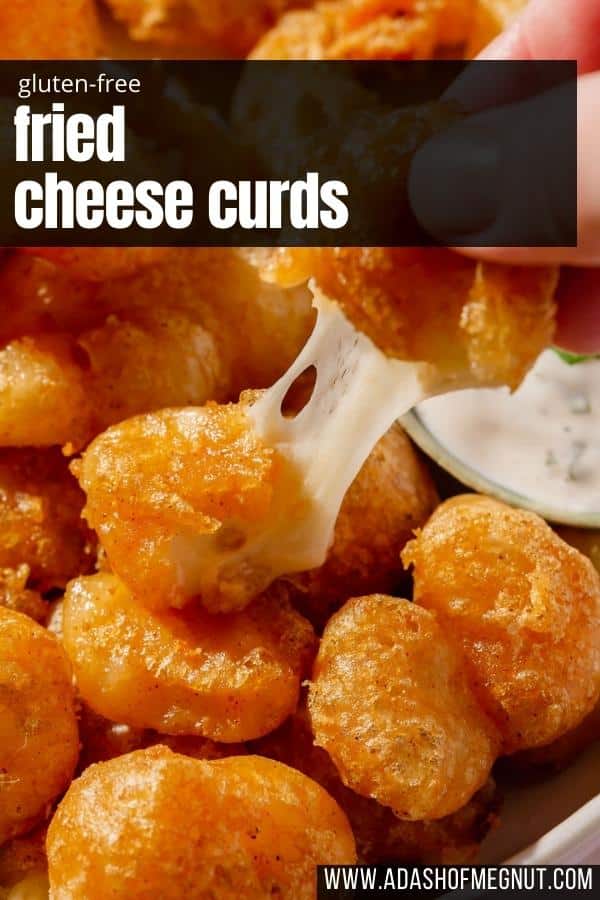 A hand pulling apart a gluten-free cheese curd to see the cheesy center.