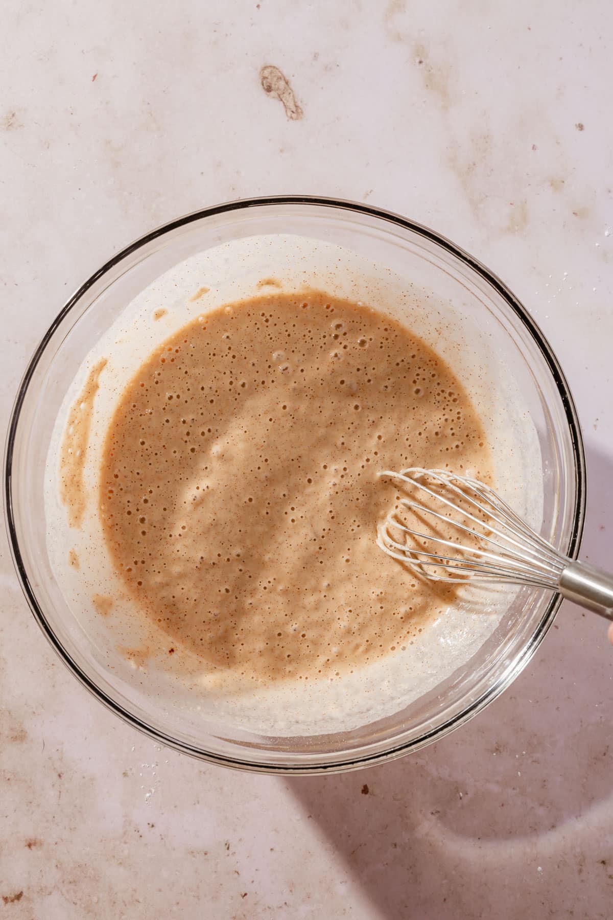 A bowl of gluten-free frying batter with a whisk.