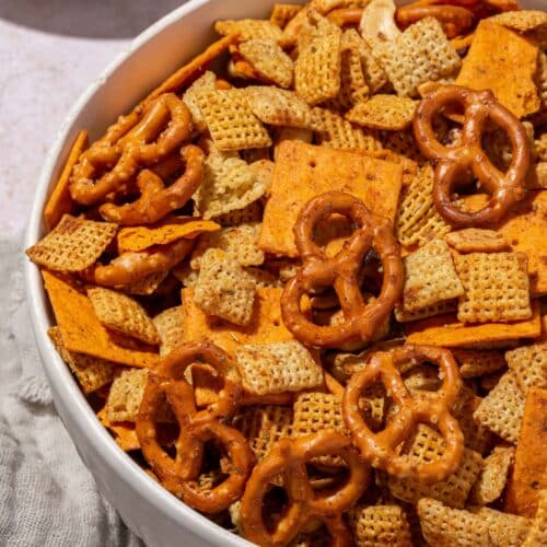 A closeup of a large serving bowl with chex mix in it.