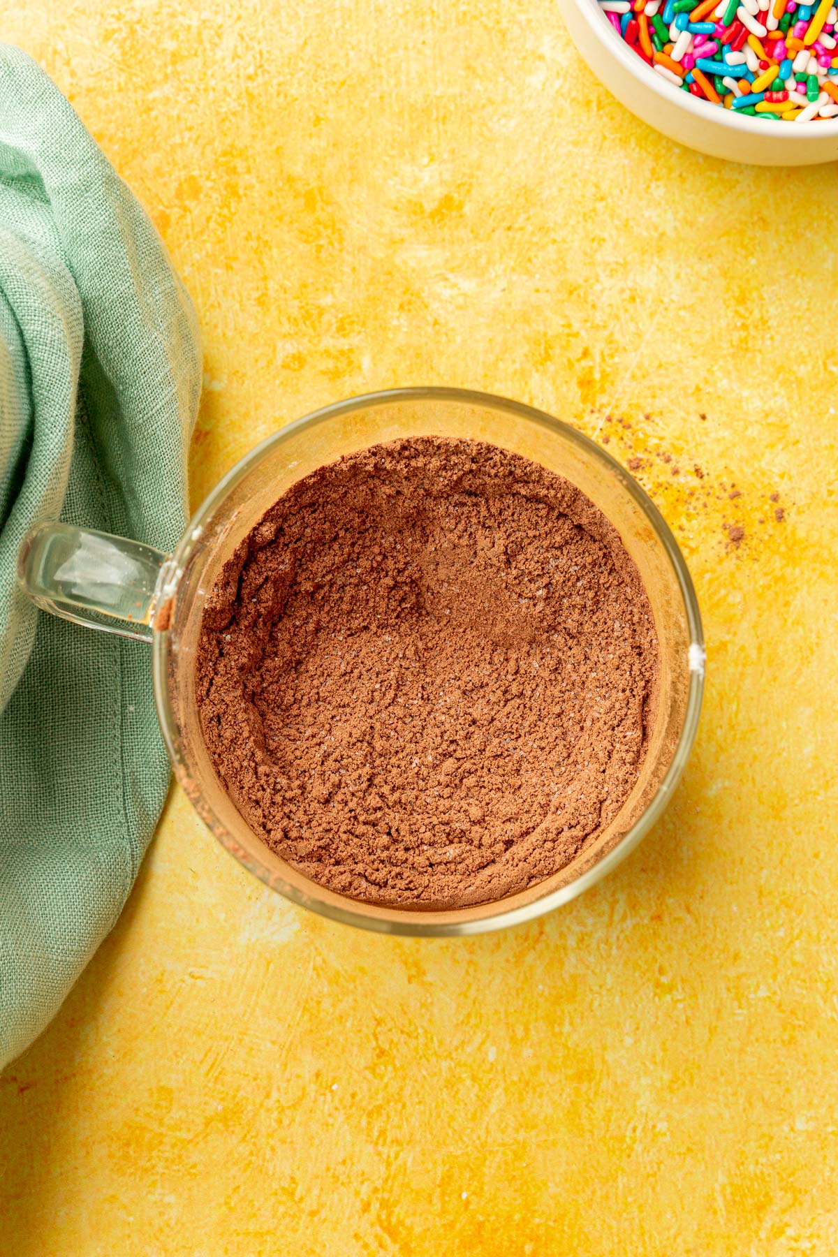 A cocoa powder and gluten-free flour mixture in a glass mug.
