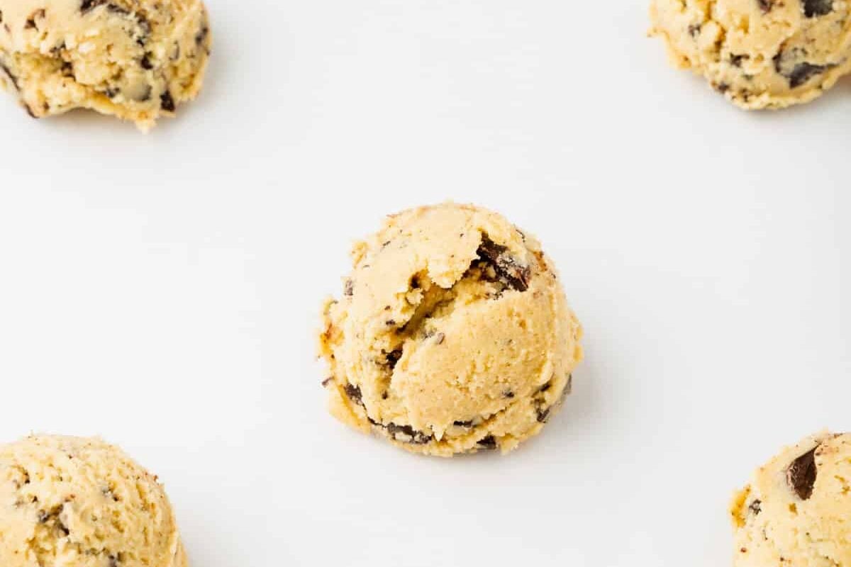 Gluten-free chocolate chip cookie dough balls on parchment paper.