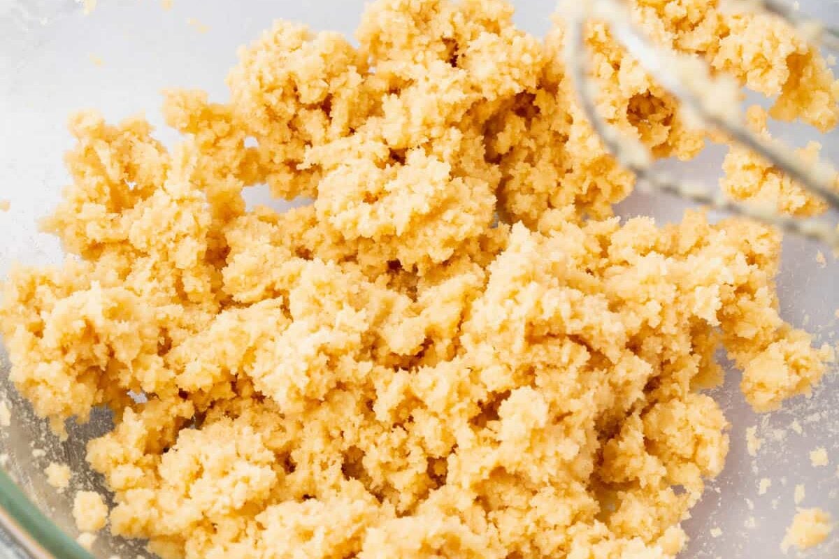 A glass mixing bowl with a creamed butter and sugar mixture in it.