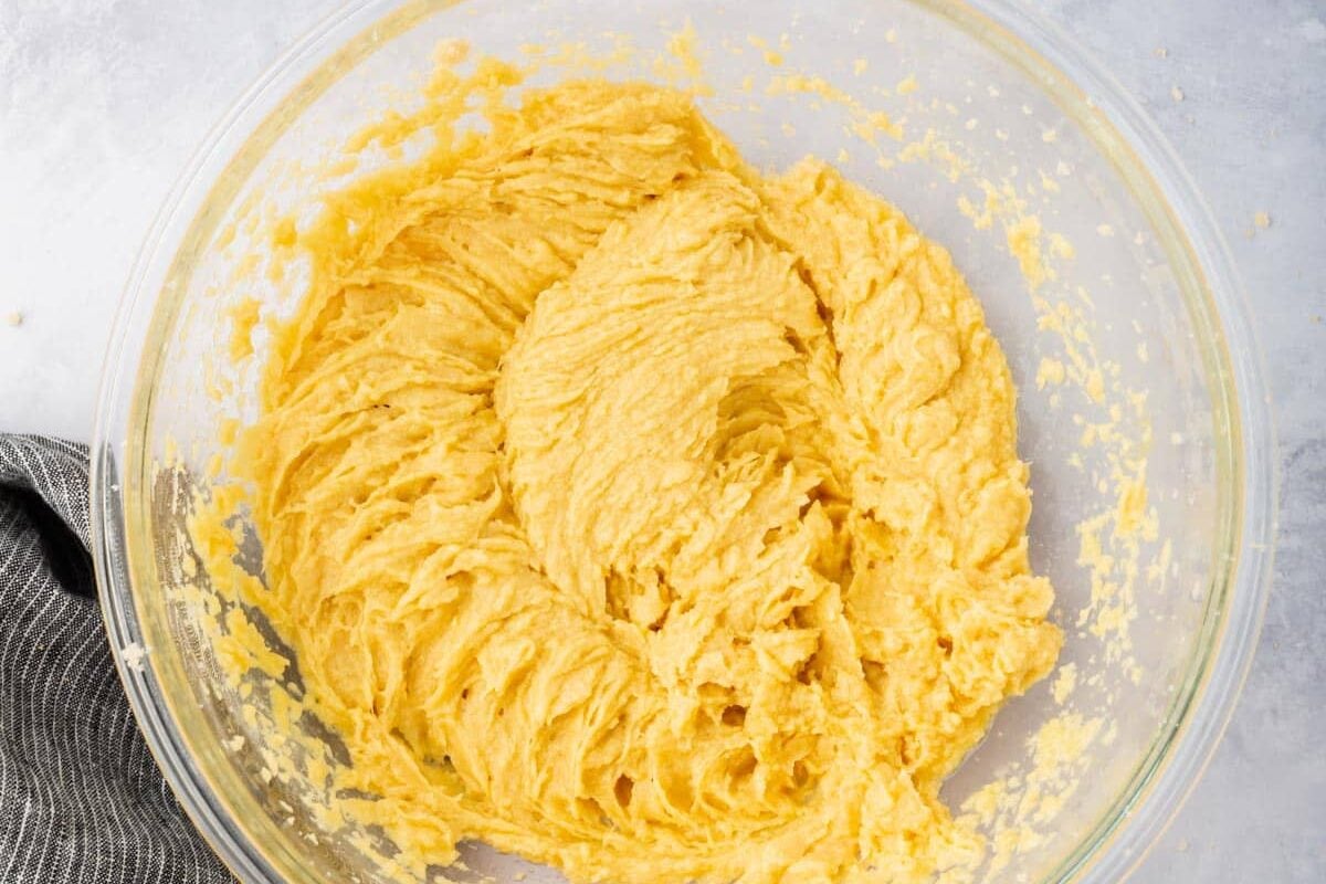 A glass mixing bowl with a creamed butter and sugar mixture in it.